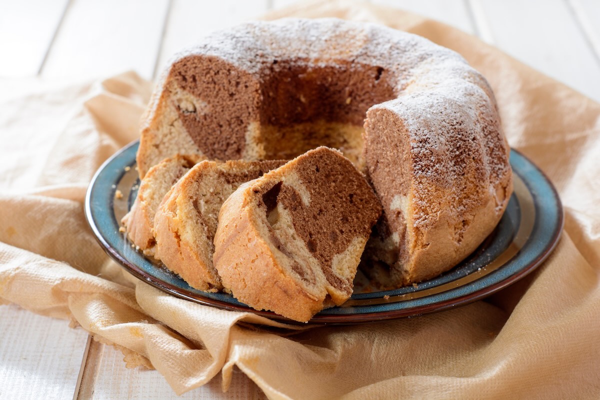 Dvojfarebná domáca bábovka posypaná práškovým cukrom na tanieri