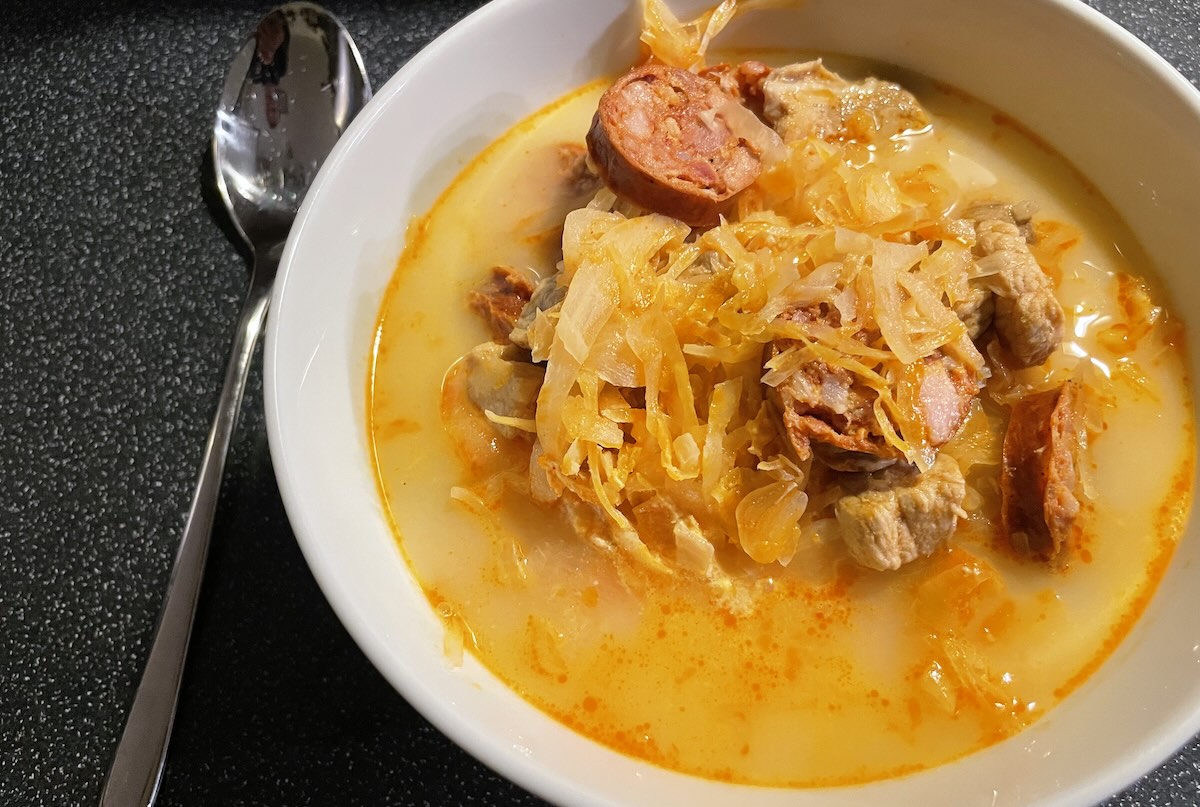 Kapustnica s kyslou kapustou, mäsom, klobásou a smotanou v bielej miske