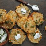 Chrumkavé domáce zemiakové placky so smotanovým dipom a bylinkami podávané na drevenom stole