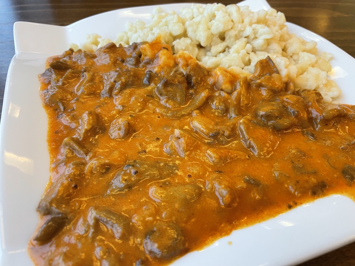 Hlivový perkelt na paprike s haluškami na bielom tanieri