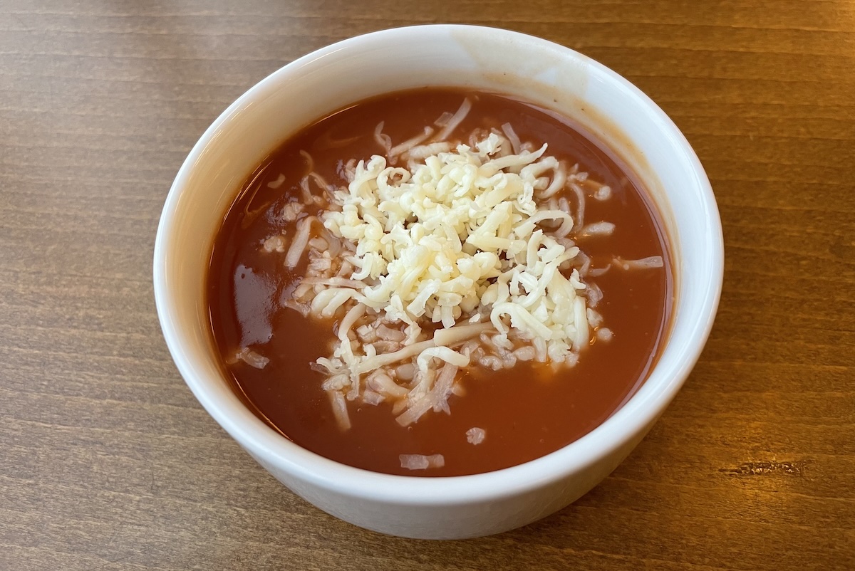 Klasická rajčinová polievka so strúhaným syrom v bielej miske