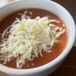 Paradajková polievka z pretlaku posypaná strúhaným syrom