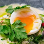Vajce namäkko s tekutým žĺtkom prekrojené na polovicu podávané na šaláte