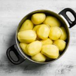 Ošúpané zemiaky v hrnci zaliate studenou vodou pred varením