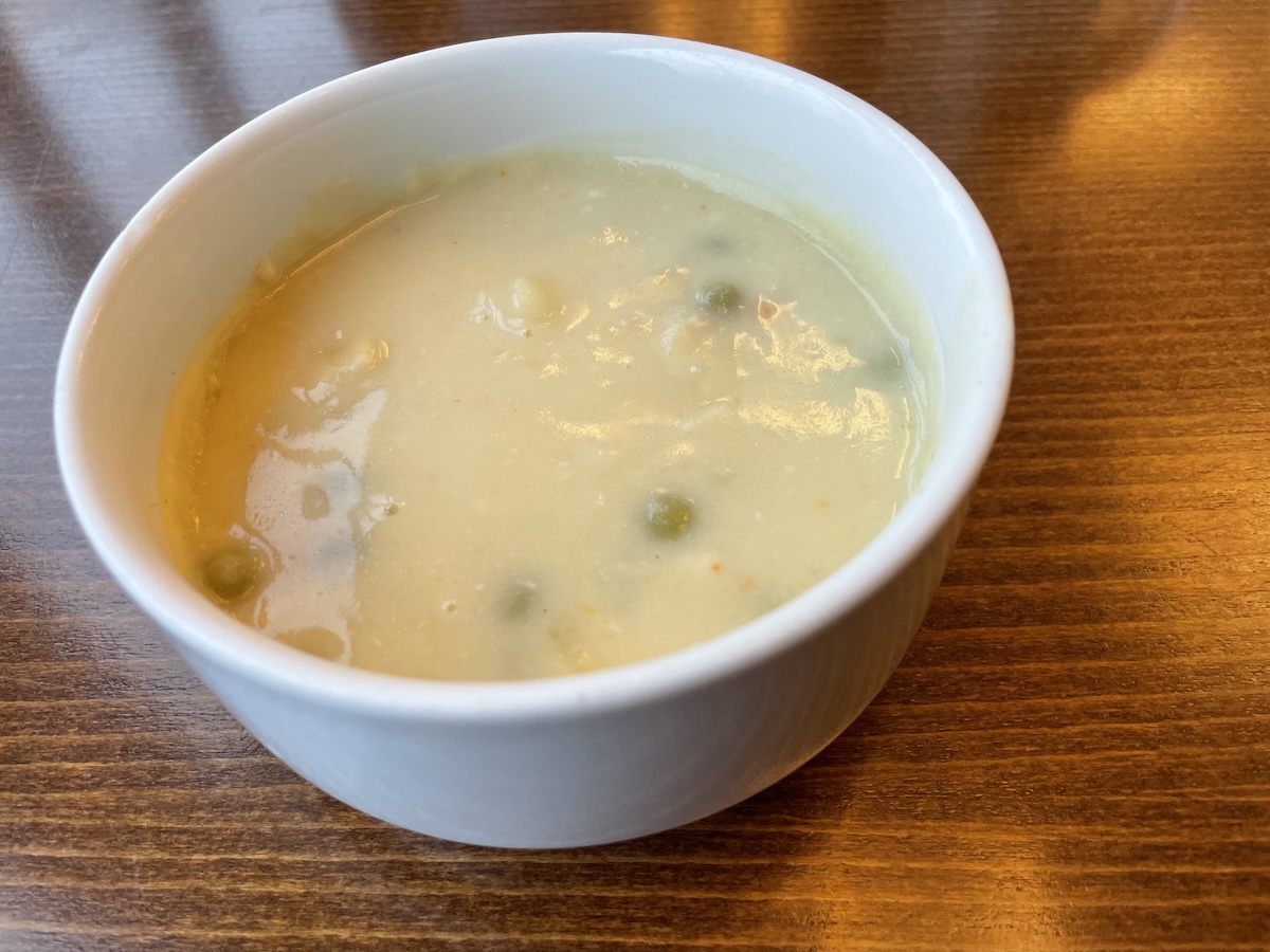 Domáca zemiaková polievka s hráškom podávaná v bielej miske