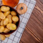 Zemiaky v šupke pripravené na varenie v miske na drevenom stole