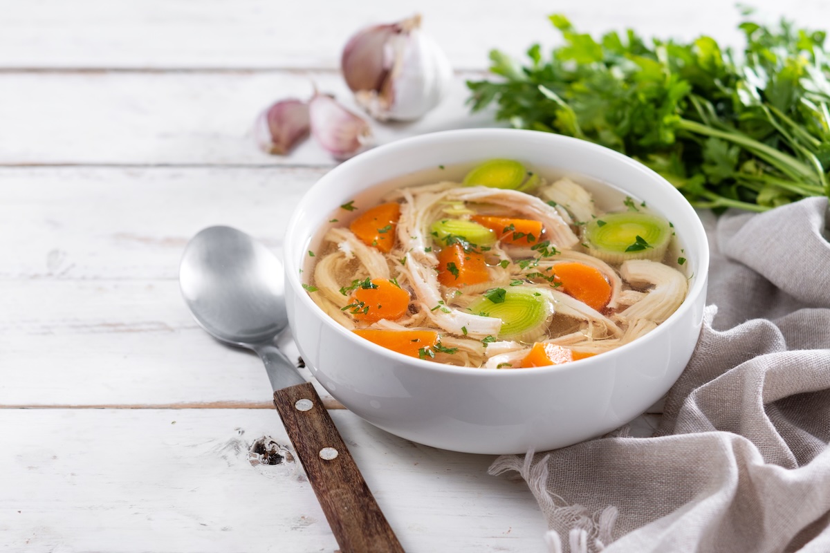 Číry domáci kurací vývar s rezancami, mrkvou, zeleninou a kúskami mäsa podávaný v bielom tanieri