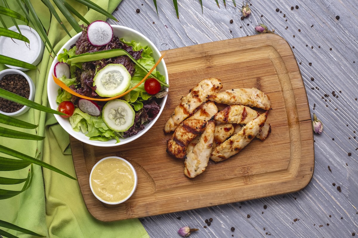 Grilované kuracie prsia nakrájané na kúsky podávané so zeleninovým šalátom