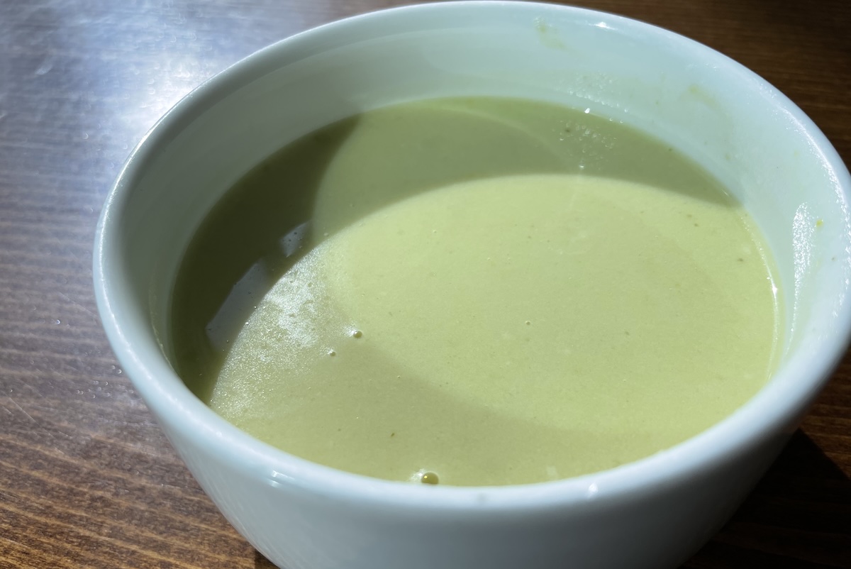 Krémová hrášková polievka so smotanou podávaná v miske