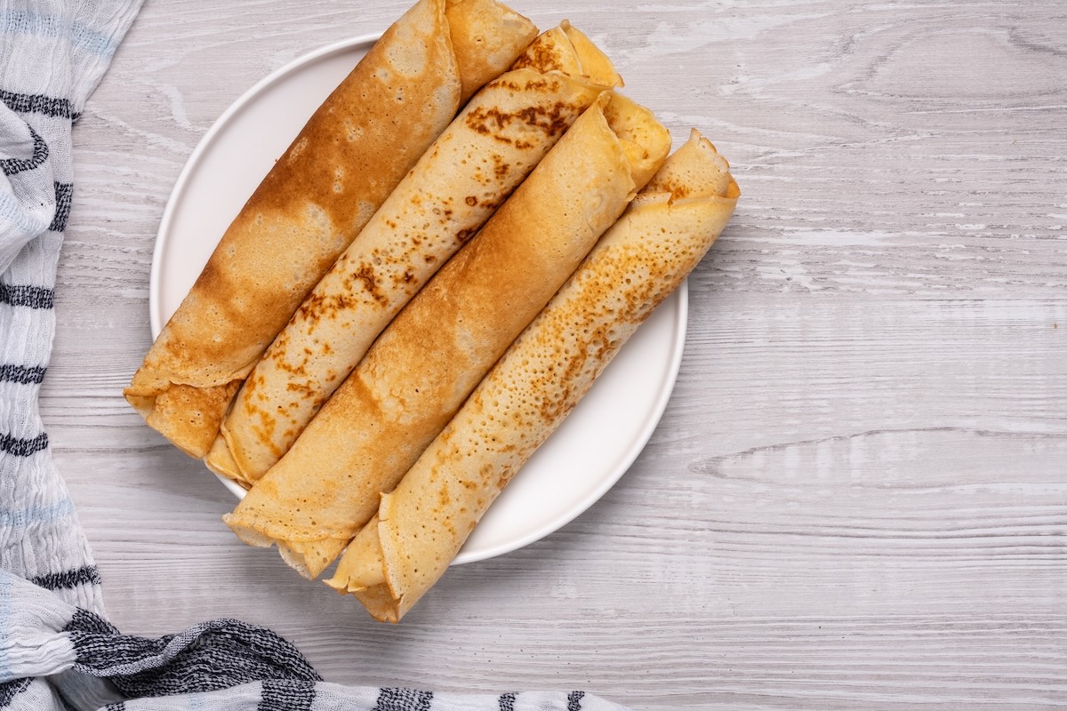 Tenké domáce palacinky stočené do roliek na bielom tanieri