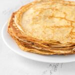 Vysoký stoh tenkých domácich palacínok na bielom tanieri