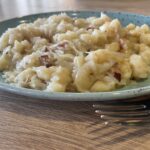 Kapustové halušky so slaninou (jednoduchý domáci recept) Kapustové halušky so slaninou a kyslou kapustou na modrozelenej keramickej miske