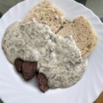 Kôprová omáčka s hovädzím mäsom a knedľou na bielom tanieri