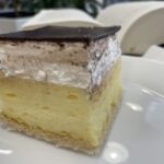 Domáci krémeš na tanieri s vanilkovým krémom, šľahačkou a čokoládovou polevou