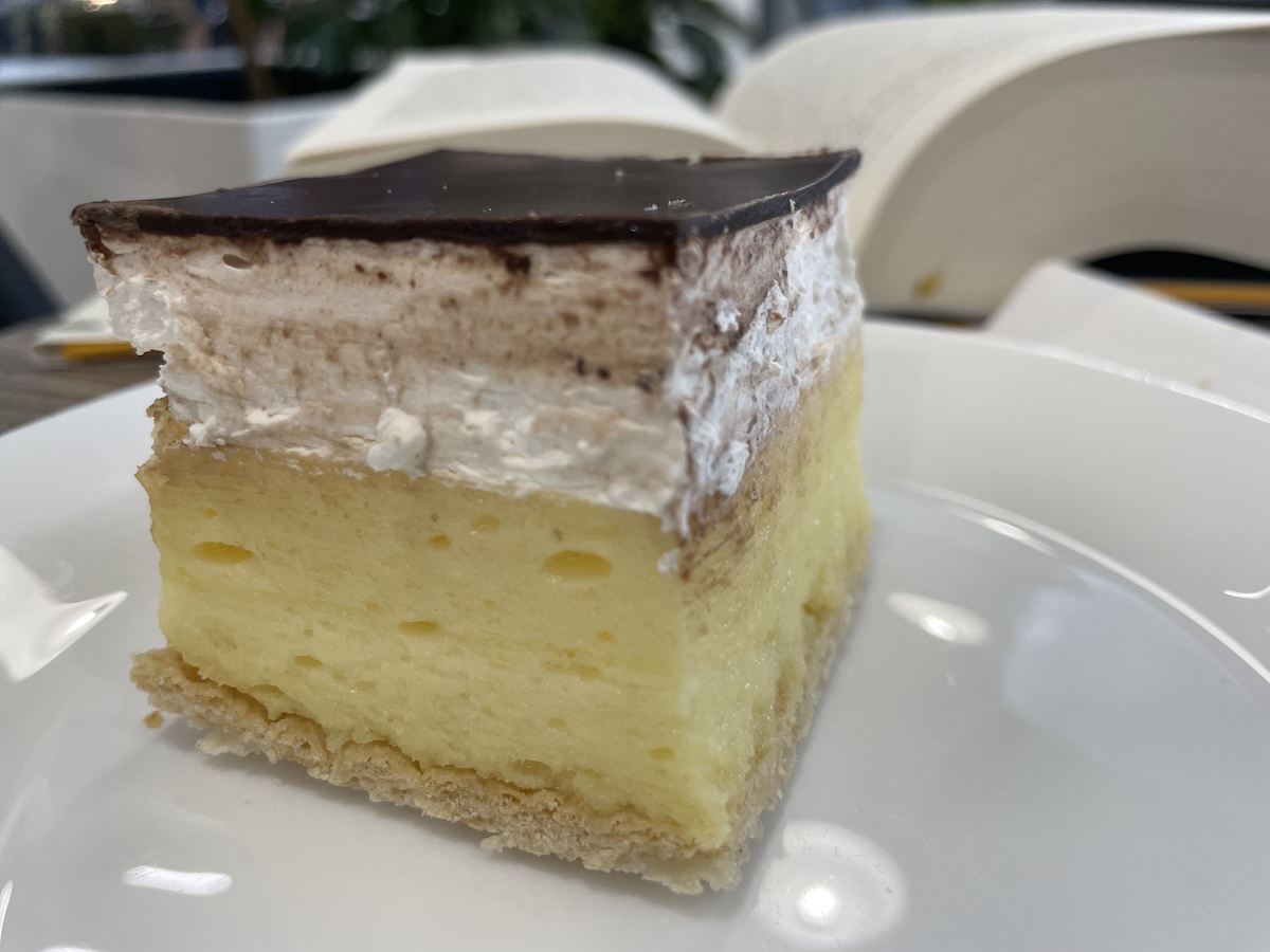 Domáci krémeš na tanieri s vanilkovým krémom, šľahačkou a čokoládovou polevou