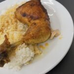 Pečené kuracie stehno s ryžou a výpekom na bielom tanieri