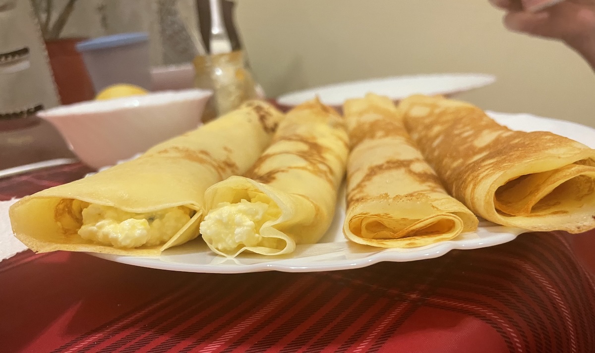 Domáce palacinky plnené tvarohom stočené na bielom tanieri