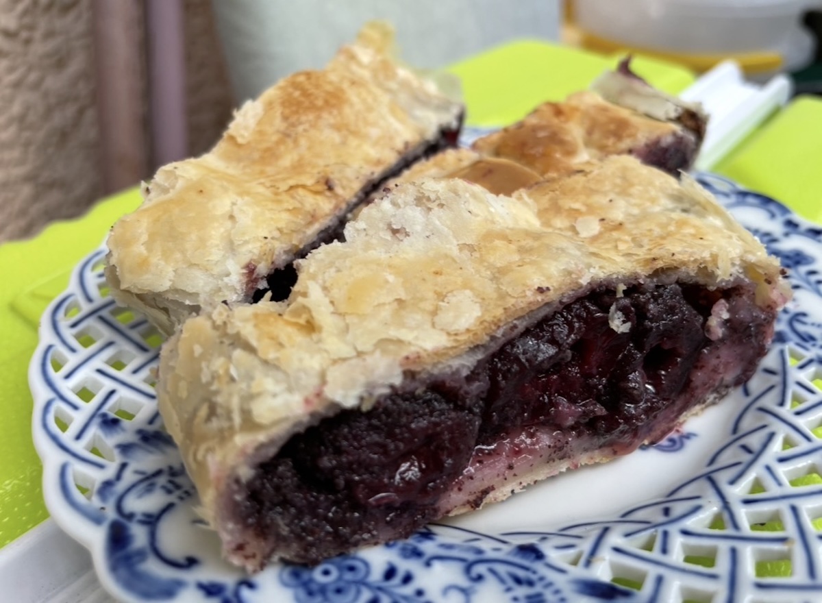 Rez štrúdle s čučoriedkovou plnkou na modrobielom dekoratívnom tanieri