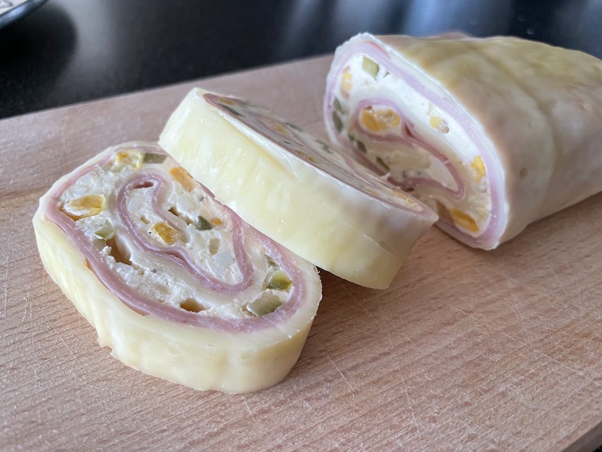 Syrová roláda nakrájaná na plátky – plnka so šunkou, kukuricou a zeleninou zavinutá v plátkoch syra