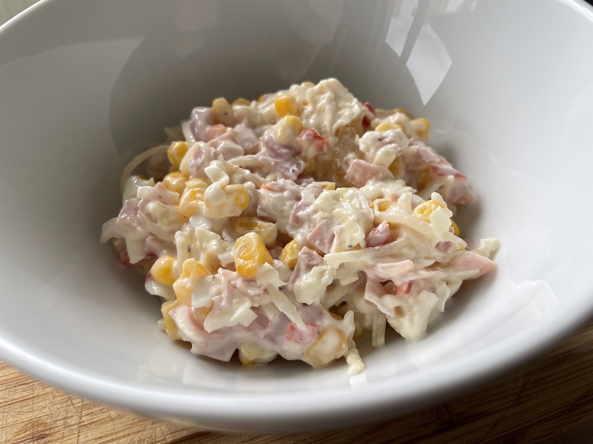 Zelerový šalát s ananásom, kukuricou a šunkou v bielej miske