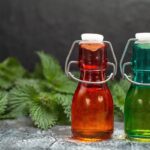 Domáci žihľavový sirup vo fľaštičkách s čerstvou žihľavou