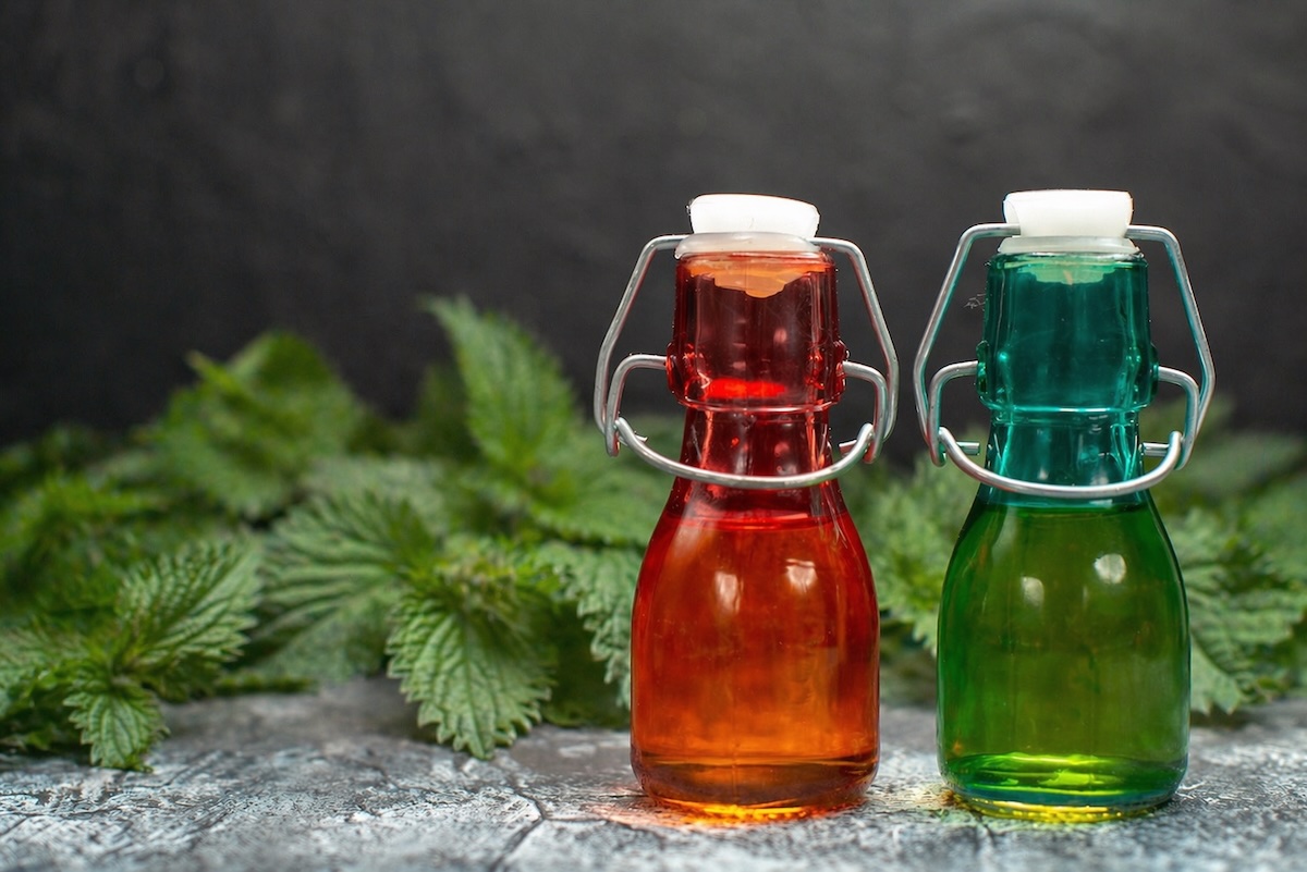 Domáci žihľavový sirup vo fľaštičkách s čerstvou žihľavou