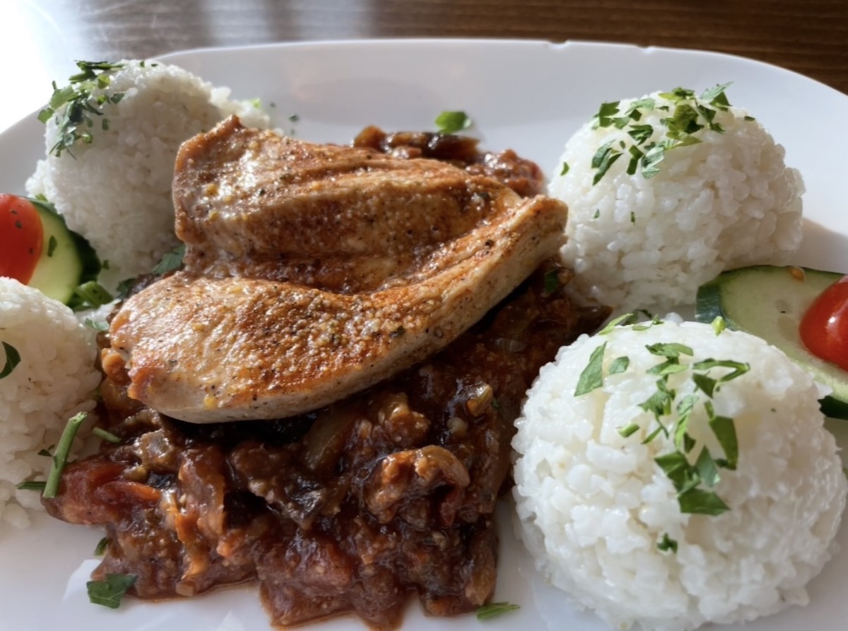 Grilovaný kurací steak s ryžou, zeleninou a omáčkou na tanieri