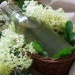 Bazový sirup: overený domáci recept krok za krokom Bazový sirup vo fľaši s kvetmi bazy čiernej v prútenom košíku