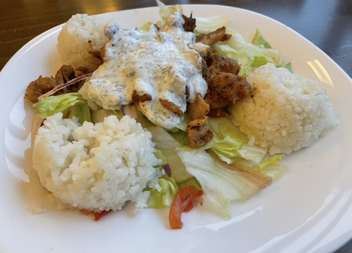 Domáci kurací kebab s ryžou, šalátom a jogurtovou omáčkou na tanieri