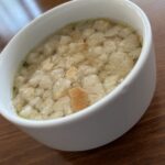 Číra cesnačka s kúskami opečeného chleba v bielej miske