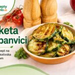 Cuketa na panvici: rýchly recept na opečené kolieska s cesnakom Opečené kolieska cukety na panvici v miske s paradajkami, cibuľou, koreničkami a vidličkou v pozadí