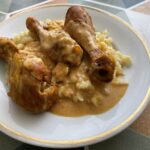 Kuracie na smotane krok za krokom, klasický domáci obed Kuracie na smotane s kuracími stehnami, krémovou omáčkou a haluškami na bielom tanieri Title: Kuracie na smotane – jednoduchý recept so šťavnatými stehnami