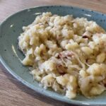 Strapačky s kyslou kapustou: tradičný recept so slaninou Domáce strapačky s kyslou kapustou a opečenou slaninou na modrom tanieri